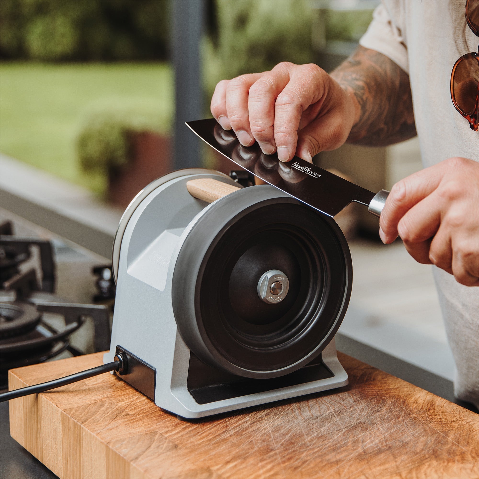 A person honing a knife on the Tormek T-1 Zinc Gray